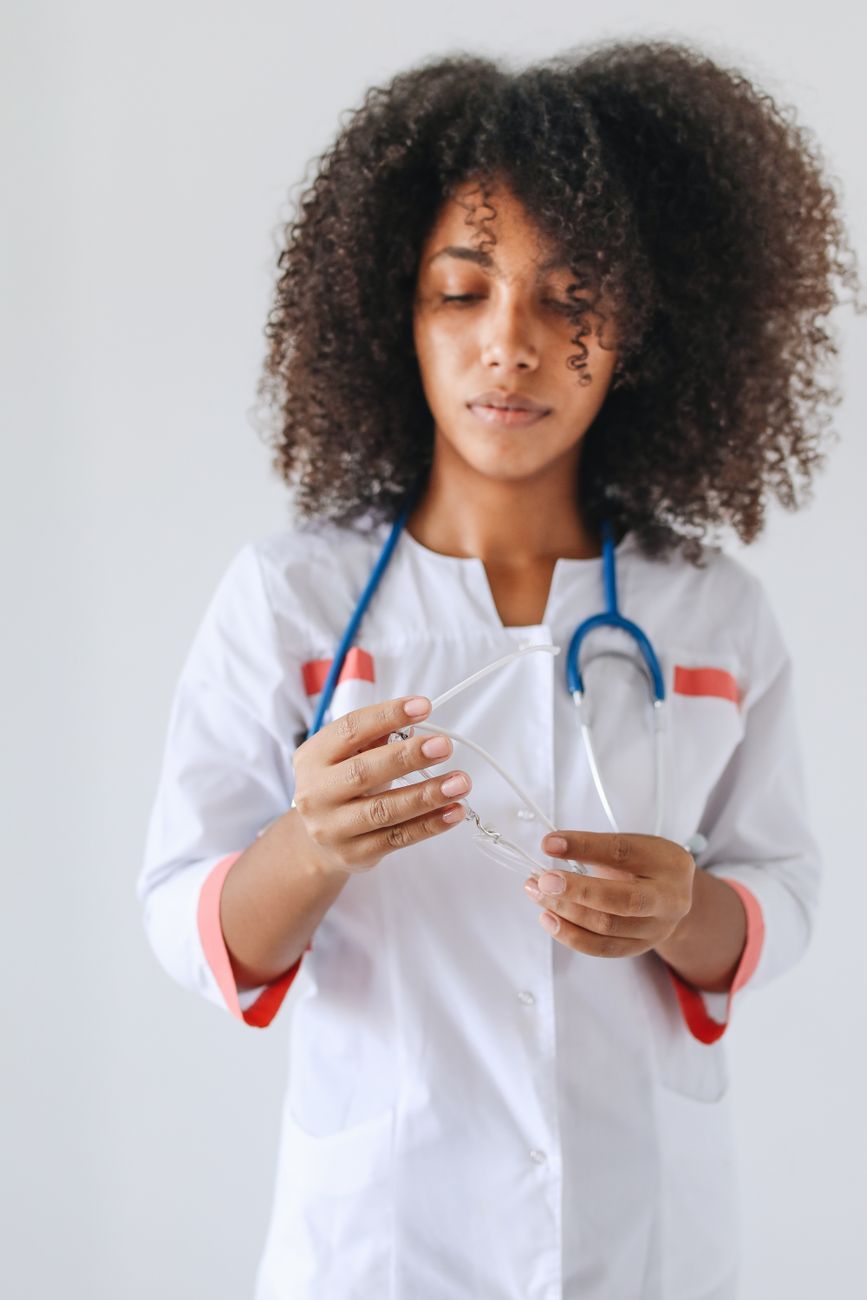 woman in white button up dress checking her eyeglasses